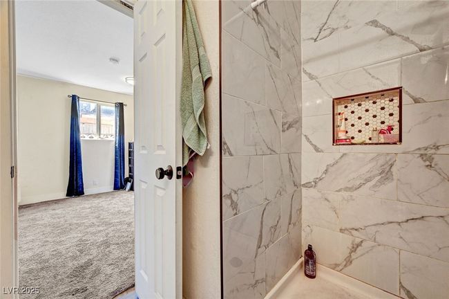 Bathroom featuring a tile shower and baseboards | Image 31