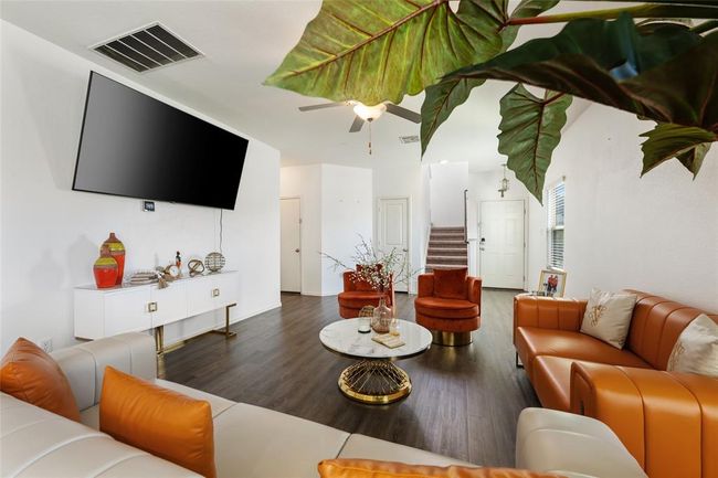 Living area with wood finished floors, stairway, and a ceiling fan | Image 4