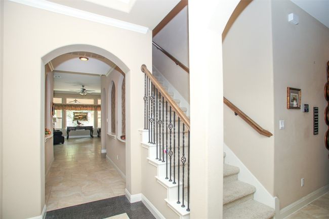 Hall featuring arched walkways, stairs, crown molding, and baseboards | Image 27