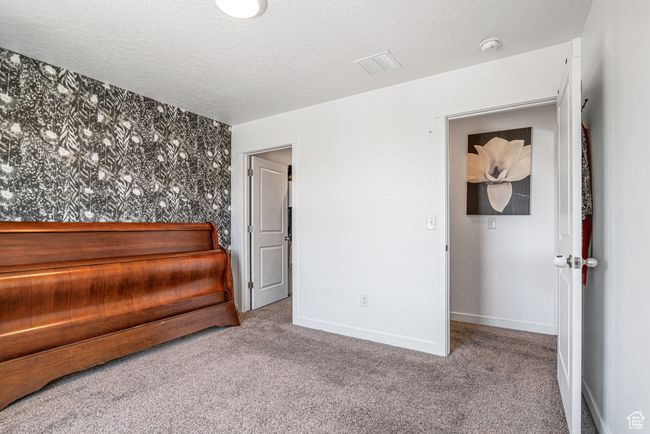Unfurnished bedroom featuring carpet, baseboards, and a textured ceiling | Image 26