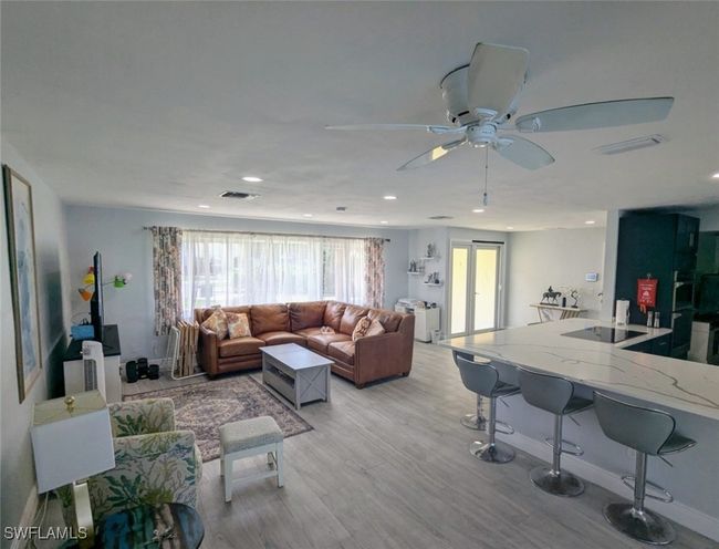 Living room featuring light wood finished floors, recessed lighting, ceiling fan, and visible vents | Image 17