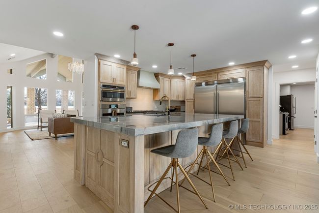 Main kitchen with luxury counters, luxury appliances, bar seating, and custom cabinets | Image 19