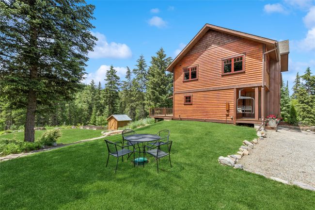 View of property with a storage shed, a yard, and a deck | Image 5