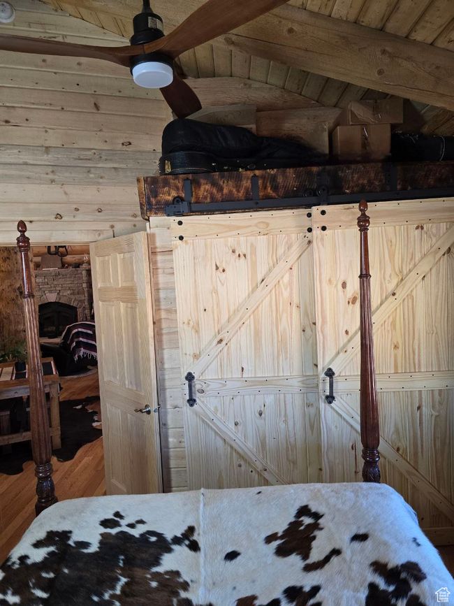 Unfurnished bedroom with wooden walls, wood ceiling, and wood finished floors | Image 90