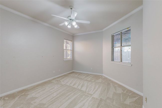 Unfurnished room featuring light colored carpet, crown molding, baseboards, and ceiling fan | Image 20
