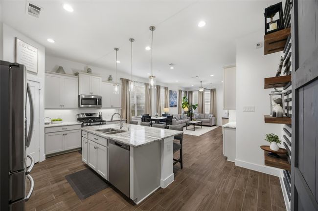 The heart of the home shines in this stunning island kitchen, complete with gleaming granite countertops, stainless steel appliances, and pendant lighting that enhances both style and function. | Image 6