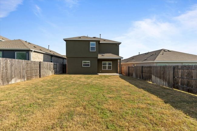 Rear view of house with a yard, stucco siding, roof with shingles, and a fenced backyard | Image 19