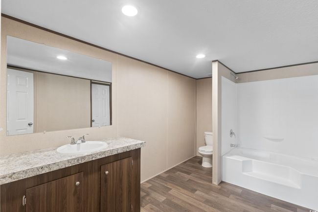 Full bathroom featuring vanity, wood finished floors, bathing tub / shower combination, and recessed lighting | Image 30