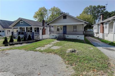 Bungalow-style house with covered porch and a front yard | Image 1