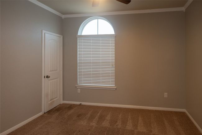 Spare room with crown molding, carpet, a ceiling fan, and baseboards | Image 19