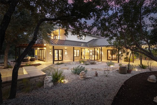 Front view of house with metal roof, a patio area, a standing seam roof, French doors and landscaped area | Image 11