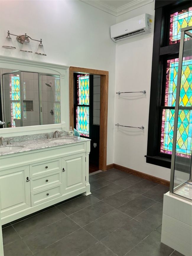 Full bathroom with plenty of natural light, a stall shower, double vanity, and crown molding | Image 16