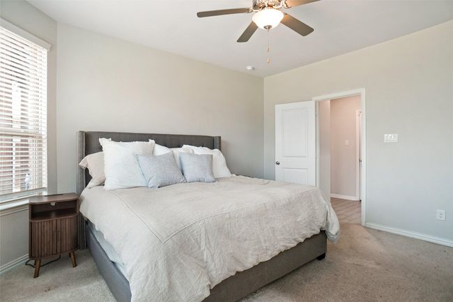 Carpeted bedroom with multiple windows, baseboards, and a ceiling fan | Image 10