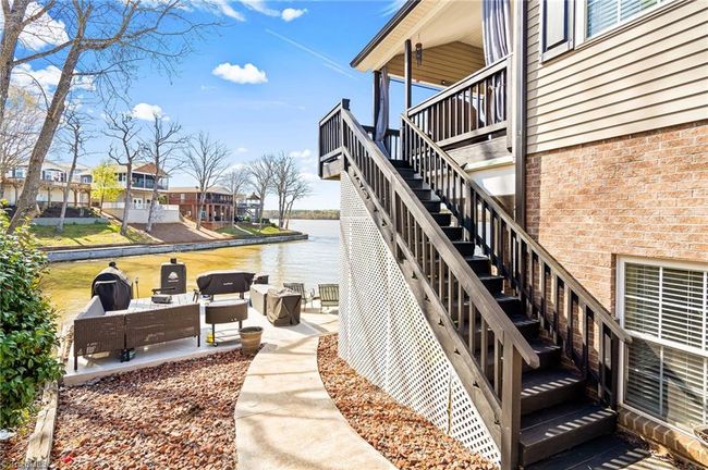 Concrete sidewalk on both sides of the house that lead down to the water & outside sitting areas | Image 37