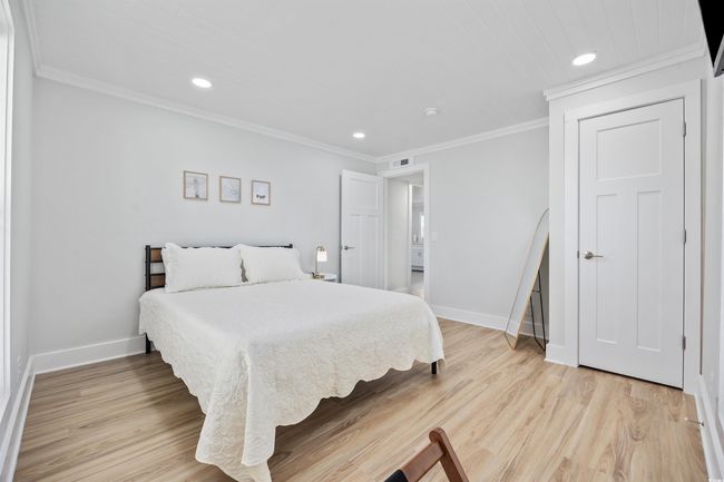 Bedroom with baseboards, recessed lighting, crown molding, and light wood finished floors | Image 12