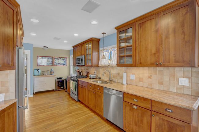 Kitchen with pendant lighting, stainless steel appliances, light stone countertops, and sink | Image 14