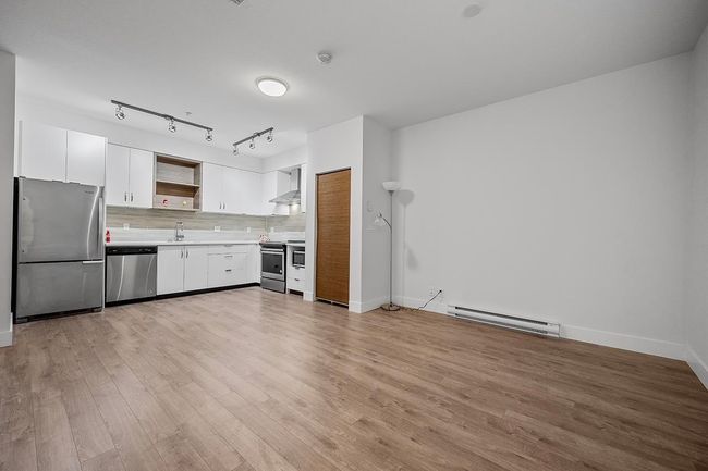 Kitchen featuring stainless steel appliances, a baseboard radiator, open shelves, light countertops, and light wood-style flooring | Image 10