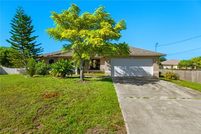 View of front of home with a front yard and a garage | Image 1