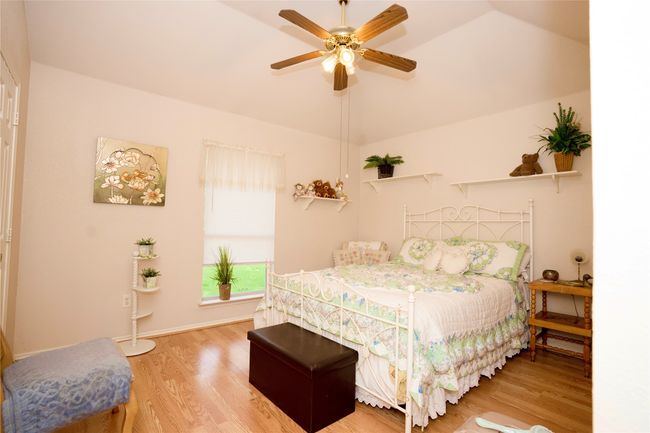 Bedroom with light wood-style flooring, lofted ceiling, and ceiling fan | Image 21