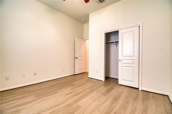 Unfurnished bedroom featuring a closet, baseboards, light wood finished floors, and visible vents | Image 7