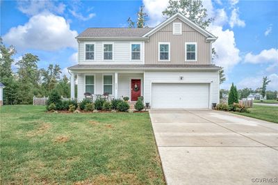 View of front property with a garage, covered porch, and a front yard | Image 1