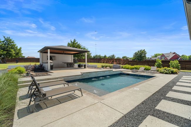 View of swimming pool with a patio and a fenced backyard | Image 33
