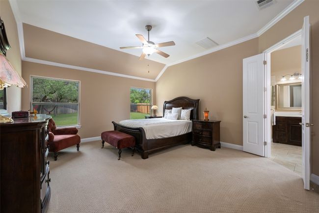 Bedroom with light carpet, crown molding, ensuite bathroom, lofted ceiling, and ceiling fan | Image 20