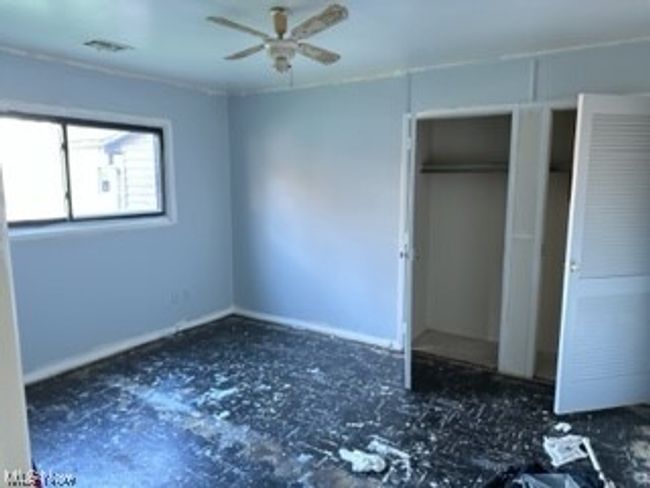 Unfurnished bedroom with ceiling fan and a closet | Image 10