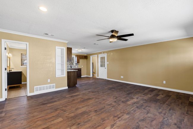 Unfurnished living room with dark wood-style floors and visible vents | Image 24