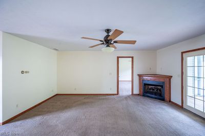 Unfurnished living room with ceiling fan and carpet flooring | Image 3