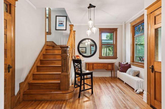 Foyer/front entrance with renovated 1/2 bathroom on the left side. Stunning original hardwood flooring throughout the home. | Image 11