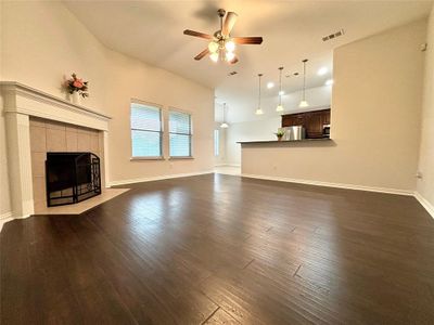 Living room featuring ceiling fan, dark wood-type flooring, high vaulted ceiling, and a tile fireplace | Image 3