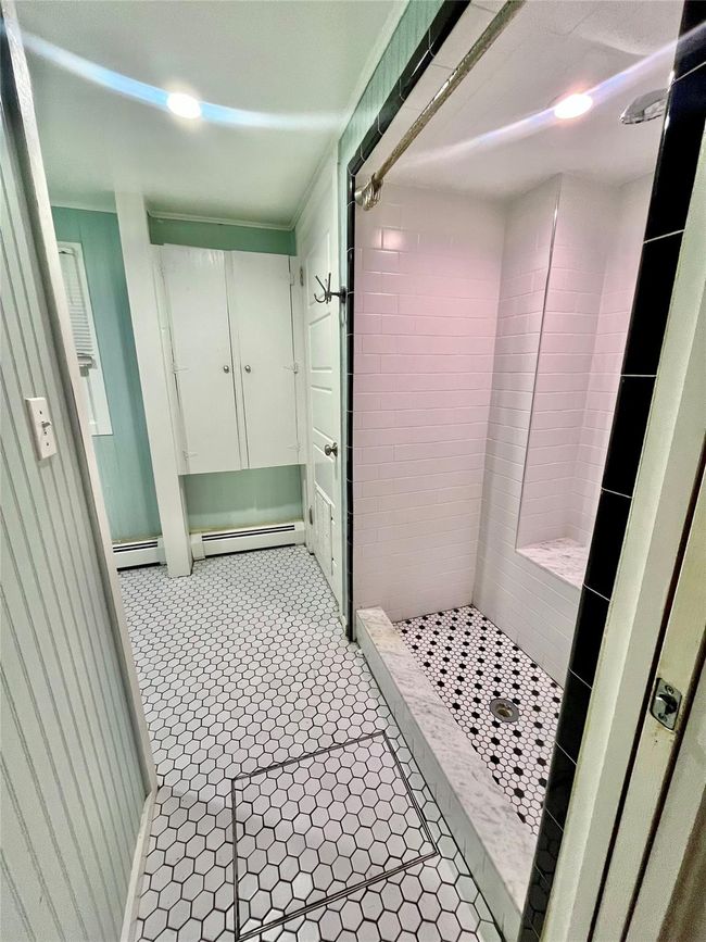Bathroom featuring baseboard heating and a stall shower | Image 7