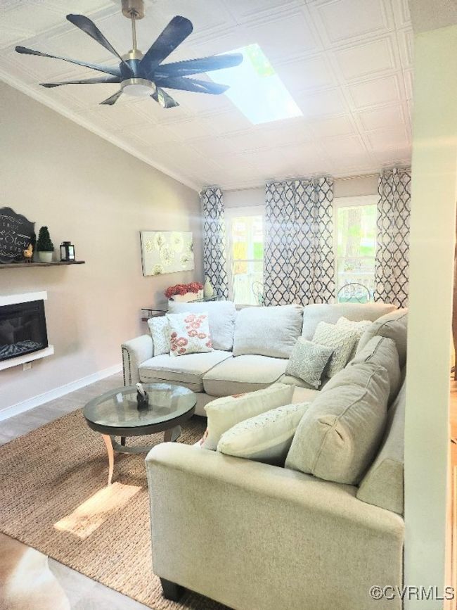 Living room with a ceiling fan and a glass covered fireplace | Image 10