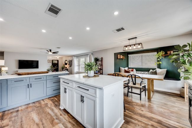 Kitchen with pendant lighting, recessed lighting, light wood-type flooring, a center island, and a ceiling fan | Image 13