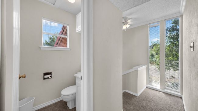 Bathroom featuring a textured ceiling, plenty of natural light, toilet, and ceiling fan | Image 19