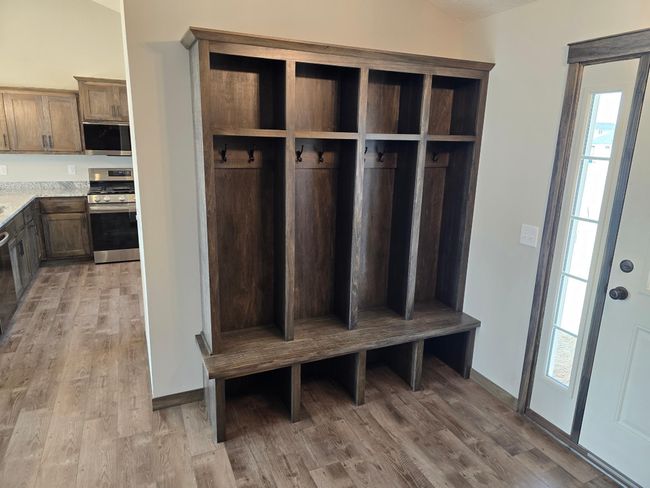 Custom bench and upper locker system with hanging hooks that will keep everyone organized and ready to go. Great unloading zone. | Image 9
