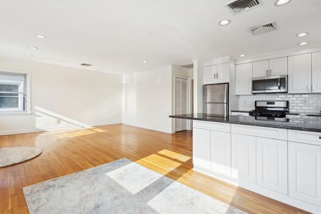 Kitchen featuring tasteful backsplash, baseboards, visible vents, white cabinetry, and appliances with stainless steel finishes | Image 8