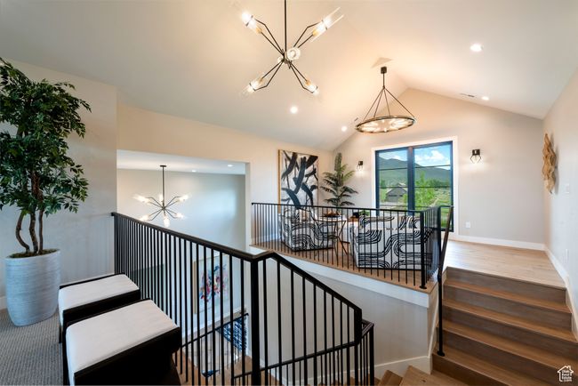 Stairs featuring a chandelier, wood finished floors, recessed lighting, and lofted ceiling | Image 39