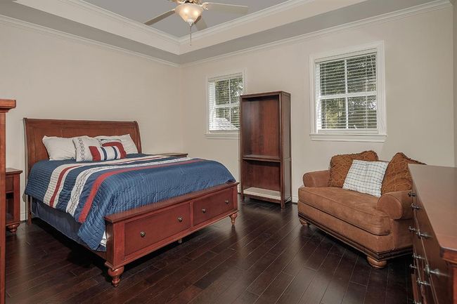 This guest bedroom has a tray ceiling, walk-in closet and en-suite bath | Image 33