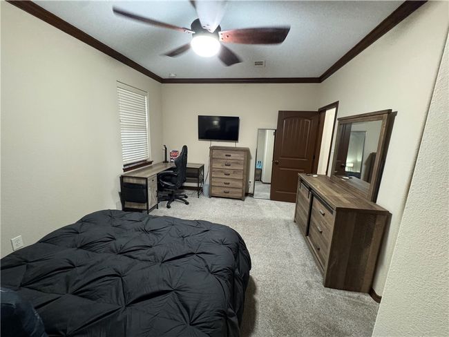 Bedroom with light carpet, crown molding, and ceiling fan | Image 17