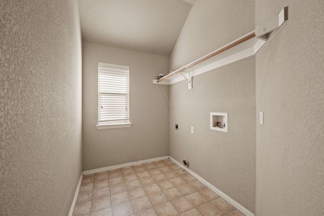Laundry room with hookup for an electric dryer, a textured wall, and laundry area | Image 17