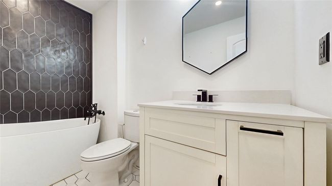 Bathroom featuring tile patterned floors, toilet, a tub to relax in, and vanity | Image 15