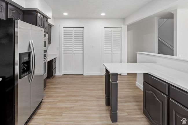 Kitchen featuring light wood-type flooring, light countertops, recessed lighting, and stainless steel appliances | Image 12