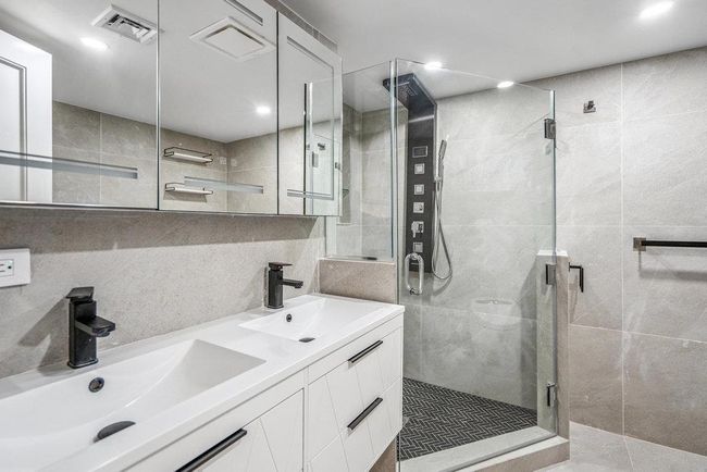 Full bath with tile walls, double vanity, a shower stall, tasteful backsplash, and recessed lighting | Image 32
