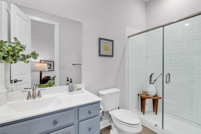 Bathroom featuring vanity, a shower with shower door, and toilet | Image 20