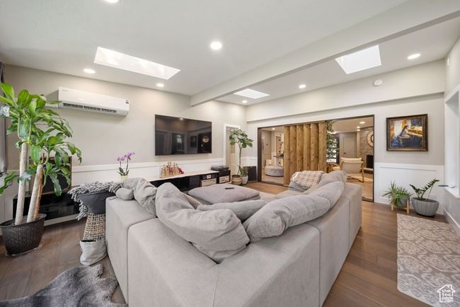Living area featuring a skylight, a wall mounted air conditioner, wood finished floors, and recessed lighting | Image 19