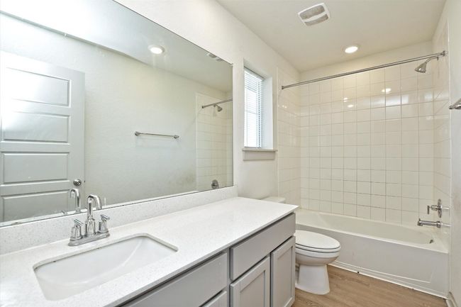 Full bath featuring toilet, wood finished floors, vanity, washtub / shower combination, and recessed lighting | Image 28