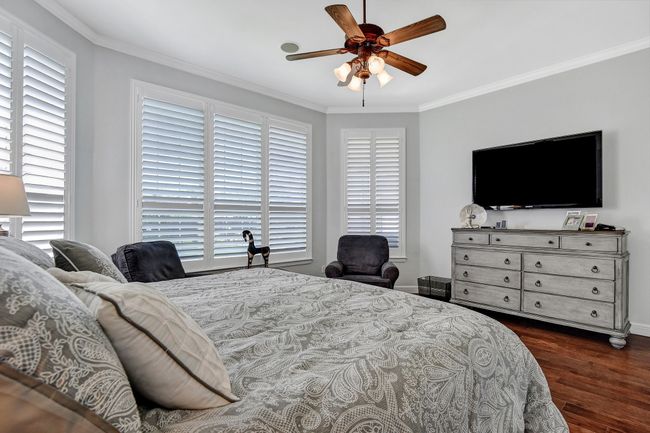 Bedroom with dark wood finished floors, crown molding, and ceiling fan | Image 19