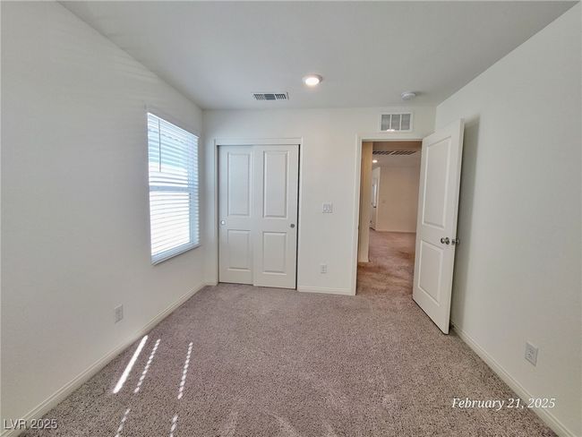 Unfurnished bedroom with baseboards, visible vents, a closet, and light colored carpet | Image 11